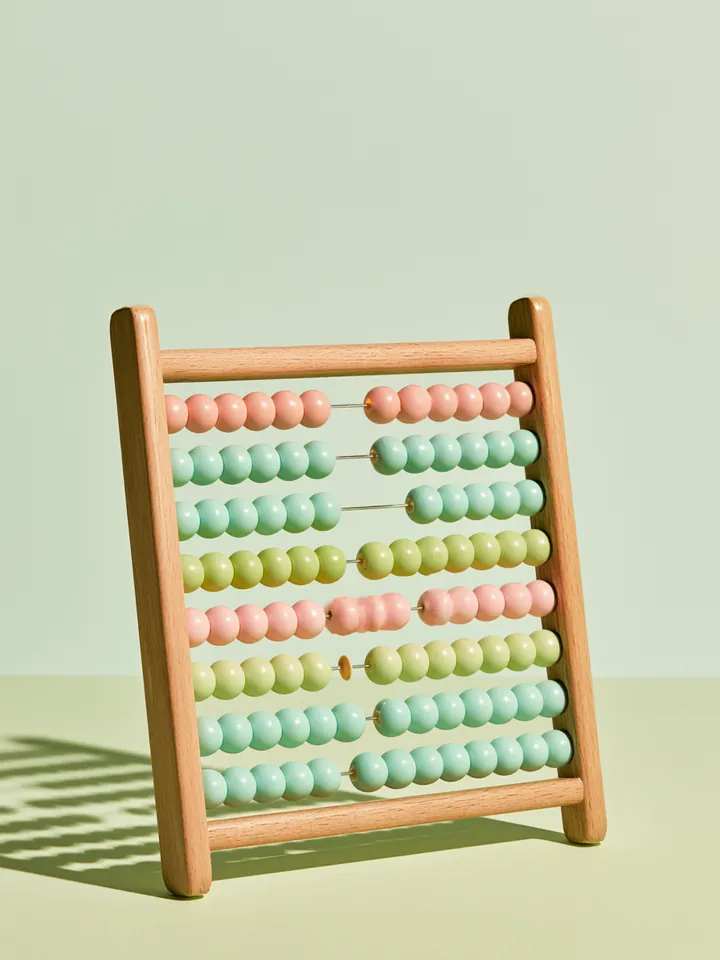 Wooden abacus with pastel beads standing upright, representing manual checks of Happy Money loan calculator results